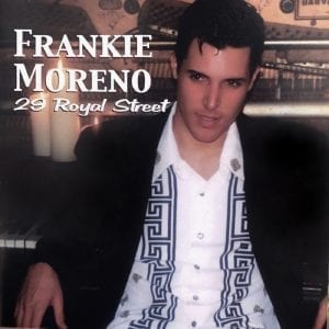A man in a black suit jacket and white patterned shirt sits at a piano, with text "Frankie Moreno 29 Royal Street".