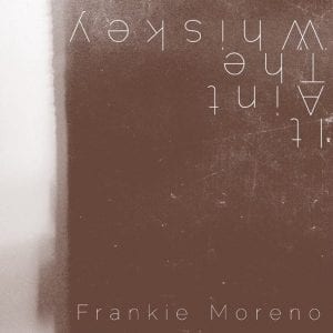 A distressed brown background with white text "IT AIN'T THE WHISKEY" rotated 90 degrees and "Frankie Moreno".