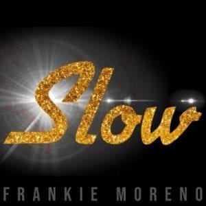 The word "Slow" in shimmering gold glitter with a bright lens flare behind it on a black background.