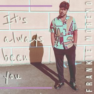 A man in a patterned shirt and dark pants stands against a wall with "It's always been you" and "FRANKIE MORENO" text.