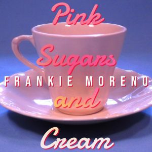 A light pink teacup and saucer with "Pink Sugars FRANKIE MORENO and Cream" in pink and yellow text.